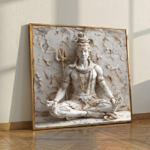 May include: A white relief sculpture of a seated figure with long hair, a trident, and jewellery, framed in gold. The figure is in a meditative pose, with hands resting on the knees. The background has a textured, aged appearance.