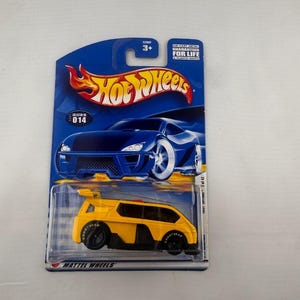 May include: A yellow Hot Wheels die-cast toy car on a blue and white card. The car has black wheels and a spoiler. The card features the Hot Wheels logo and the text "GUARANTEED FOR LIFE".