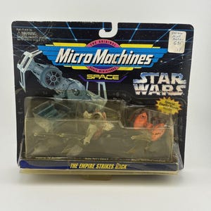May include: A vintage Micro Machines Star Wars toy set, featuring miniature vehicles from "The Empire Strikes Back." The packaging includes an Imperial TIE Bomber, Boba Fett's Slave I, and a Bespin Twin-Pod Cloud Car. The package reads "The Empire Strikes Back."