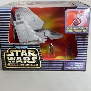May include: A Star Wars Action Fleet toy set in its original packaging. The box features a gray spacecraft, two miniature figures, and the text "OPENING COCKPIT! Poseable figures fit inside."