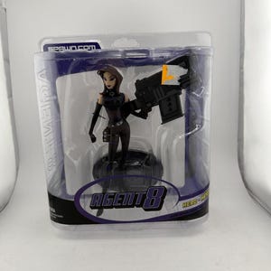 May include: A white ceramic mug with a black handle and the text "But First, Coffee" in a black, bold font. The mug is on a white surface. The mug is 4 inches tall.