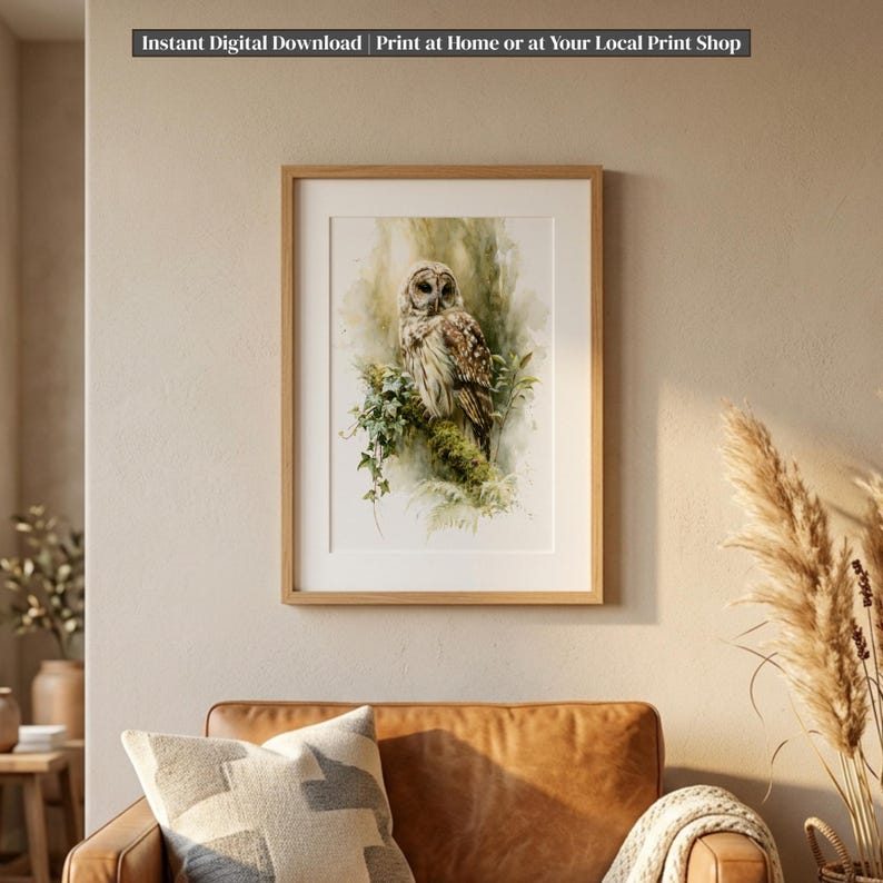 Watercolor owl printable wall art displayed in natural wood frame above cognac leather sofa in boho living room, moss and ivy botanical illustration, instant digital download print for nature home decor