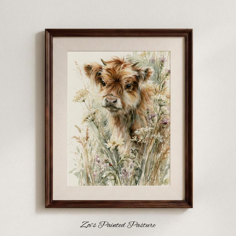 May include: A framed watercolour print featuring a fluffy brown Highland calf surrounded by delicate white and purple wildflowers. The artwork is encased in a dark brown wooden frame with a light beige mat, and the text Zoi's Painted Pasture is below.