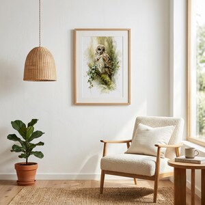 Watercolor owl printable wall art displayed in natural wood frame in a bright Scandinavian minimalist living room with boucle chair, fiddle leaf fig plant, woven pendant light, and jute rug