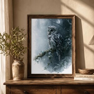 Barred owl watercolor printable wall art in rustic wood frame leaning on farmhouse console table with ceramic vase and stacked books, moody blue forest cottagecore home decor digital download print