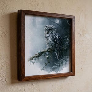Barred owl watercolor printable wall art displayed in a dark walnut wood frame mounted on a textured plaster wall, featuring a mystic owl perched on an ivy branch in moody blue-green forest tones