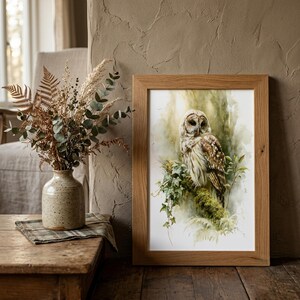 Watercolor owl printable wall art in natural oak frame leaning against rustic plaster wall, styled with dried eucalyptus botanicals and linen chair, cottagecore farmhouse home decor digital download print