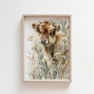 Watercolor highland cow calf printable wall art in natural wood frame on white wall, featuring baby highland cow surrounded by wildflowers and a hidden ladybug, farmhouse nursery decor digital download