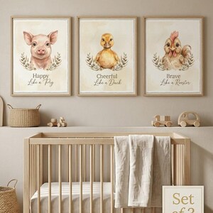 May include: A set of three framed wall art prints featuring watercolor illustrations of a pig, a duck, and a rooster. Each animal is surrounded by a leafy wreath. The text reads Happy Like a Pig, Cheerful Like a Duck, and Brave Like a Rooster.