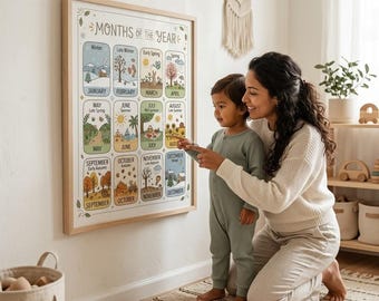 May include: A framed wall poster titled Months of the Year featuring twelve illustrated rectangular panels, each representing a month with seasonal imagery, colors, and text labels, displayed in a grid format with a light wood frame.