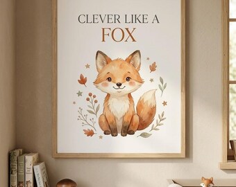 May include: A framed wall art print featuring a cartoon fox sitting in the center, surrounded by small leaves, berries, and stars. The text "CLEVER LIKE A FOX" is printed in dark brown letters above the fox illustration on a white background.
