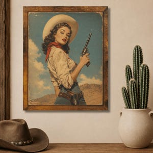 Puede incluir: Una impresión de arte mural enmarcada que presenta una ilustración de estilo vintage de una vaquera con sombrero de vaquero blanco, camisa color crema con flecos y pañuelo rojo, y jeans azules, sosteniendo un revólver frente a un paisaje desértico.