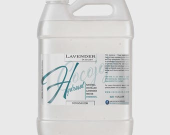 Puede incluir: Una garrafa de plástico transparente de un galón que contiene hidrosol de lavanda. La etiqueta presenta el texto Lavender, Dr. Joe Lab, Cocojojo e Hydrosol, junto con información del producto, una dirección web y un icono de Facebook.