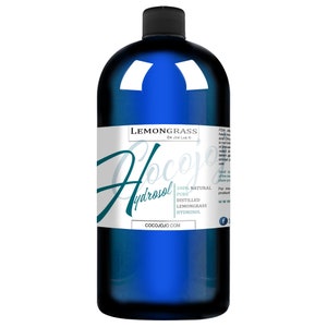 Pu&ograve; includere: Una bottiglia di vetro blu con un'etichetta bianca che recita "Lemongrass Hydrosol" e "100% Naturale Puro Idrolato di Lemongrass Distillato". L'etichetta include anche il sito web "cocojojo.com" e un logo di Facebook.