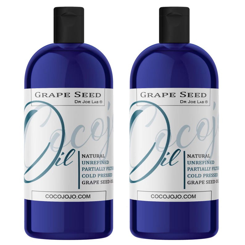 May include: Two dark blue bottles of CocoJojo Grape Seed Oil. Each bottle has a black cap and a white label with the text "Grape Seed" and "Coco Oil". The label also includes the text "Natural Unrefined Partially Filtered Cold Pressed Grape Seed Oil" and "COCOJOJO.COM".