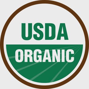 May include: A circular USDA Organic seal with a brown border. The top half of the circle is white with the text "USDA" in green. The bottom half is green with the word "ORGANIC" in white.