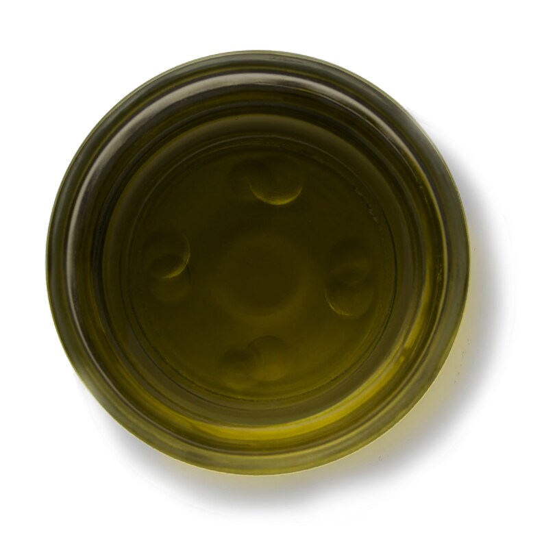 May include: A clear glass jar filled with a golden yellow liquid, possibly olive oil or honey. The jar has a wide mouth and a thick rim.