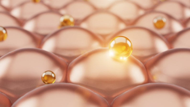 May include: Close-up of a textured, peach-colored surface with small, golden spheres scattered across it. The spheres are shiny and reflect light.