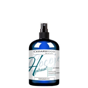 May include: A blue glass bottle with a black spray nozzle, labeled "Cedarwood Hydrosol 100% Natural Pure Distilled Cedarwood Water Hydrosol Cocojojo.com Dr. Joe Lab&reg;"