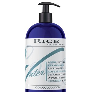 May include: A blue plastic pump bottle with a white label that reads "RICE DR JOE LAB®" and lists the ingredients: "100% NATURAL FERMENTED RICE WATER ROSE HYDROSO VITAMIN C & B5 D-PANTHENOL GLYCERIN & SO" and the website "COCOJOJO.COM".