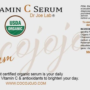 May include: A label for Organic Vitamin C Serum by Dr Joe Lab. The label features the words "Organic Vitamin C Serum" in black and a stylized orange "Serum" script. Includes "USDA Organic" seal and ingredient list.