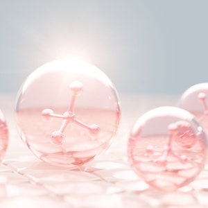 May include: Close-up of pink spheres containing a pink molecular structure. The spheres are on a white textured surface.