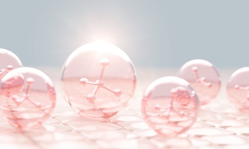 May include: Close-up of pink spheres containing a pink molecular structure. The spheres are on a white textured surface.