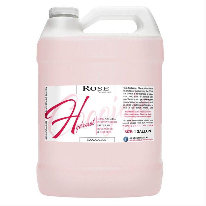 Puede incluir: Una botella de pl&aacute;stico rosa de un gal&oacute;n de hidrolato de rosa. La etiqueta dice "Rose Hydrosol" con el nombre de la empresa "CocoJojo.com" y el texto "100% natural Hidrosol puro Agua de rosas destilada y glicerina". La etiqueta tambi&eacute;n incluye una exenci&oacute;n de responsabilidad de la FDA e informaci&oacute;n sobre la vida &uacute;til del producto.