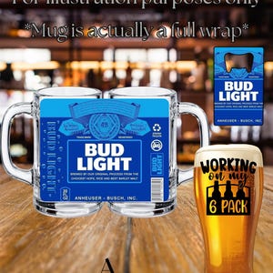 May include: A clear glass beer mug featuring a full-wrap Bud Light label with blue and white text, including the Bud Light logo, Anheuser-Busch branding, and a 20 fl oz capacity mark. A separate glass of beer with the text Working on my 6 Pack.