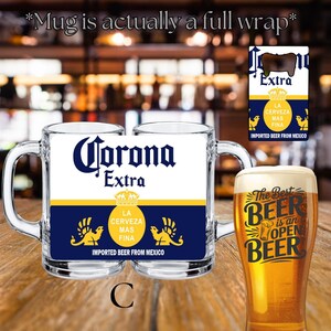 May include: A clear glass beer mug featuring a full-wrap Corona Extra label with blue, white, and yellow colors, including the text Corona Extra, La Cerveza Mas Fina, and Imported Beer From Mexico. A separate bottle opener displays the same branding.