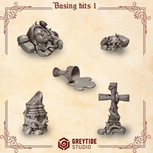 May include: A collection of five grey miniature basing bits labeled Basing bits 1 and Greytide Studio. The set includes a sculpted face with roses, a skull with roses, a spilled goblet, a broken stone pillar, and a cross wrapped in vines.