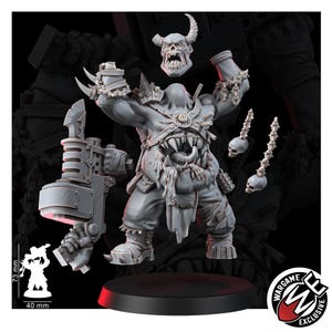 May include: A gray resin miniature of a hulking, horned creature with a toothy maw in its torso, holding a large mechanical weapon. The figure includes a separate horned head, two skull-topped chains, and a base. A scale graphic shows 73 mm by 40 mm.
