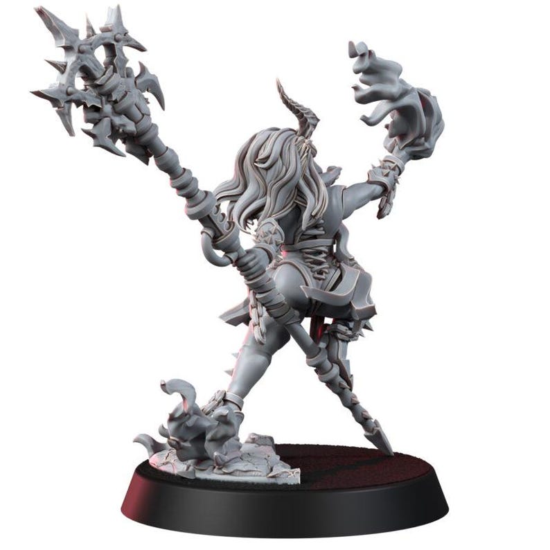 May include: A grey unpainted miniature figurine of a horned humanoid character standing on a circular base. The figure holds a large spiked staff in one hand and has flowing hair, wearing armour with a laced back detail and tattered fabric elements.