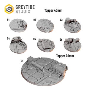 May include: A collection of grey resin miniature base toppers from Greytide Studio. The set includes six 40mm circular toppers and one 90mm circular topper, each featuring detailed industrial debris, cracked pavement, pipes, chains, and metal grates.
