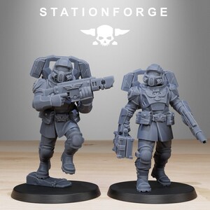 May include: Two grey unpainted resin miniature soldier figures from StationForge. Each figure wears tactical armour, a helmet with a respirator, and a jetpack. One soldier holds a rifle, while the other carries a rifle and a rectangular supply case.