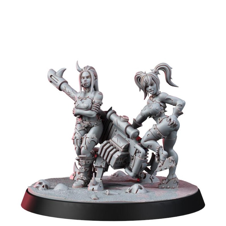 May include: A grey miniature figurine set featuring two female characters standing beside a large mechanical cannon. One character has long hair and a cigar, while the other has pigtails and a playful expression. They stand on a base with skull details.