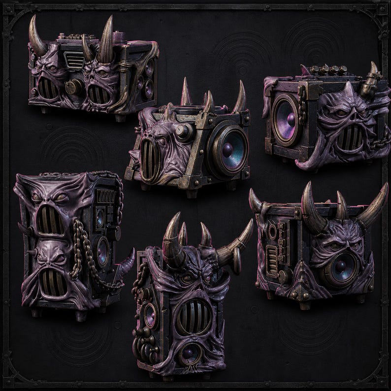 Puede incluir: Una colecci&oacute;n de cinco altavoces de color morado oscuro y negro con rostros demon&iacute;acos esculpidos, cuernos prominentes, cadenas met&aacute;licas integradas y conos de altavoz circulares. Cada unidad presenta un acabado texturizado y desgastado.