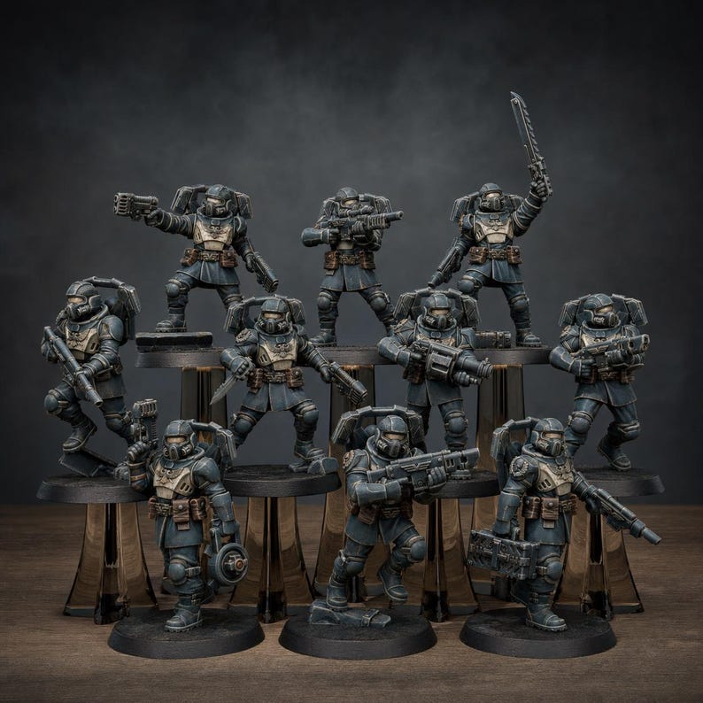 May include: A collection of ten miniature soldier figurines in dark blue and tan uniforms, each equipped with various futuristic weapons, helmets, and backpacks, standing on individual black circular bases arranged in a tiered display formation.