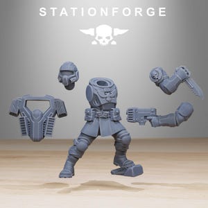 May include: A grey resin miniature model kit labelled STATIONFORGE, featuring a torso with an eagle emblem, legs, a helmet, a chest plate, and two arms. One arm holds a firearm, while the other holds a combat knife with a skull detail on the shoulder.