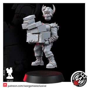 May include: A light gray miniature figurine of a humanoid creature wearing a spiked helmet with a wide, toothy grin. The figure carries a stack of four rectangular crates in its arms. A scale graphic indicates a height of 36 mm and width of 25 mm.