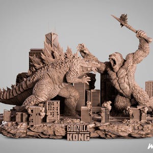 Op de afbeelding: Een gedetailleerde bruine hars sculptuur van Godzilla en King Kong in een gevechtsscène, met miniatuur stadsgebouwen. De sculptuur is 70 cm hoog en heeft de tekst "Godzilla vs Kong".