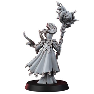 May include: A grey unpainted miniature figure standing on a black circular base. The figure wears a long flowing robe with ornate shoulder armor and holds a tall staff topped with a spiked orb and a curved horn in the other hand.