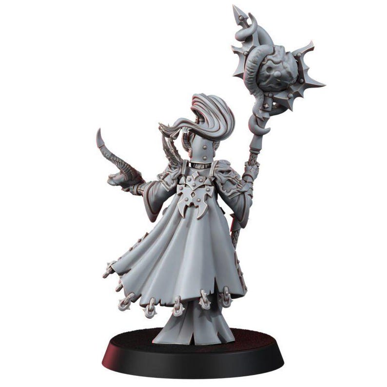 May include: A grey unpainted miniature figure standing on a black circular base. The figure wears a long flowing robe with ornate shoulder armor and holds a tall staff topped with a spiked orb and a curved horn in the other hand.