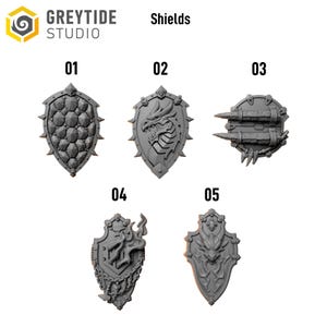 Op de afbeelding: Vijf grijze miniatuurschilden genummerd 01 tot 05 van Greytide Studio. Schild 01 heeft een schubpatroon, 02 toont een drakenkop, 03 is rond met twee horizontale stekels, 04 toont een vlammotief met kettingen en 05 toont een gehoornd wezen.