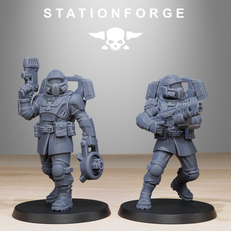 May include: Two grey resin miniature soldier figures standing on circular black bases. Each figure wears tactical armour, a helmet with a visor, and a backpack. One figure holds a pistol and a circular device, while the other holds a rifle. STATIONFORGE text.