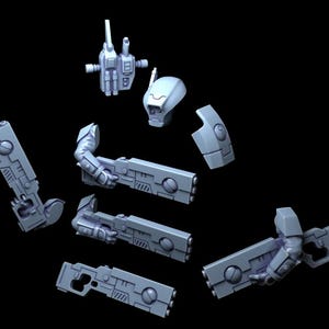 Op de afbeelding: Een lichtblauwe, onbeschilderde plastic modelbouwset met een robotachtig hoofd, een romp, een rugzak en diverse armonderdelen die lange, rechthoekige futuristische geweren vasthouden met cirkelvormige details en geometrische panelen.