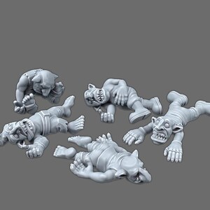 May include: A set of four unpainted gray resin miniature figures depicting goblin-like creatures in various prone and fallen positions. Each figure features pointed ears, sharp teeth, and detailed facial expressions, rendered in a matte finish.