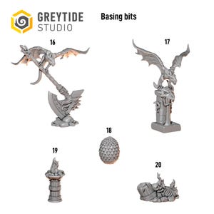 May include: Grey resin basing bits from Greytide Studio featuring five distinct miniature elements: a dragon on an axe, a dragon on a pillar, a textured egg, a stone torch, and a skeletal remains pile, labeled with numbers 16 through 20.