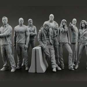 Puede incluir: Un grupo de ocho figuras en tonos grises de personas en varias poses. Algunas figuras están de pie con los brazos cruzados, mientras que otras se inclinan o señalan. Las figuras visten ropa informal, como vaqueros, chaquetas y camisetas.