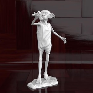 May include: A white figurine of a house elf, standing on a stone-like base. The elf is holding a small object to its ear, with one arm extended. The figure has large ears and is wearing a simple tunic.
